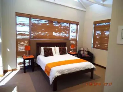 a bedroom with a bed and a large window at Riverside 18 in Hermanus