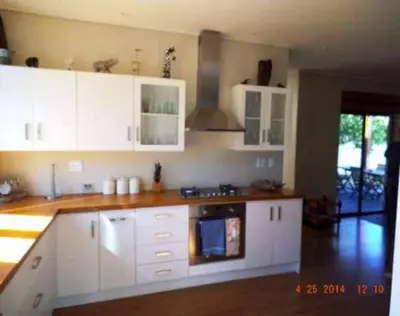 a kitchen with white cabinets and a stove at Riverside 18 in Hermanus