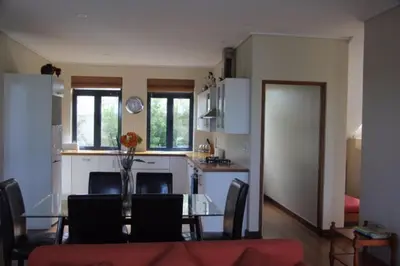 a kitchen and dining room with a glass table with a table at Riverside 18 in Hermanus