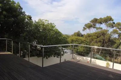 a roof deck with a view of trees at Riverside 18 in Hermanus