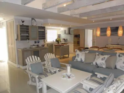 a living room with a couch and a table and chairs at Whale Rock 54 in Hermanus