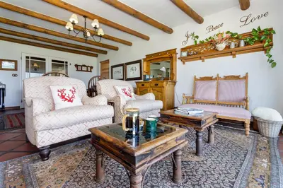 a living room with two chairs and a coffee table at Strand Beach Lodge in Strand