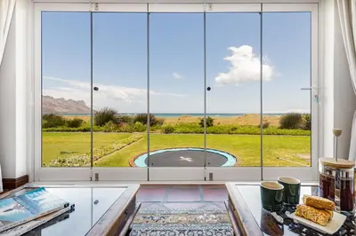 a room with a large window with a view of a pool at Strand Beach Lodge in Strand
