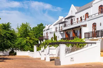 a white building with balconies on a street at De Zalze Lodge in Stellenbosch