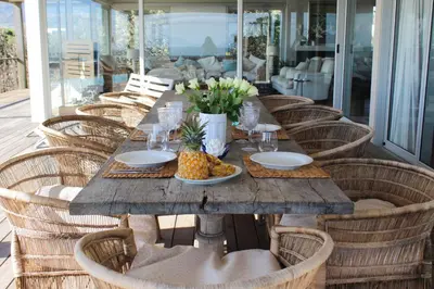 a wooden table with a plate of pineapple on it at Pringle Bay Villa in Pringle Bay
