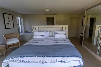 a bedroom with a large bed and a bath tub at Pringle Bay Villa in Pringle Bay