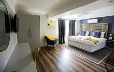 a bedroom with a large white bed and a chair at New National Hotel and Conference in Parow