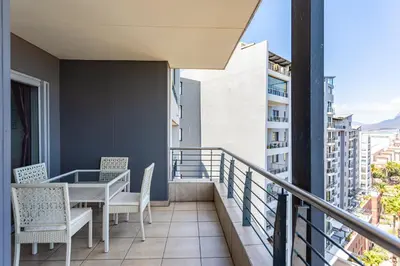 a balcony with a table and chairs on a building at Knightsbridge Luxury Suite in Century City by CTHA in Cape Town