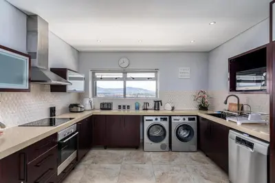 a kitchen with a washing machine and a washer and dryer at Knightsbridge Luxury Suite in Century City by CTHA in Cape Town