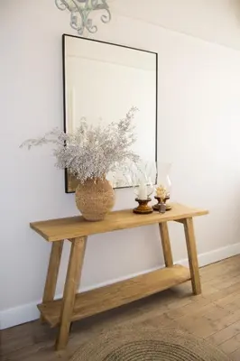 a console table with a mirror and flowers on it at Madeliefie Guest Accommodation in Paarl