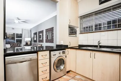 a kitchen with a washer and dryer in it at Avemore Vredehof No 2 - full Backup Power in Stellenbosch