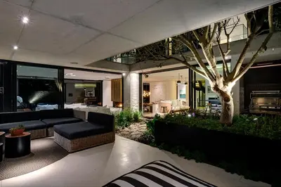 a living room with a couch and a tree at Restio River House in Pringle Bay