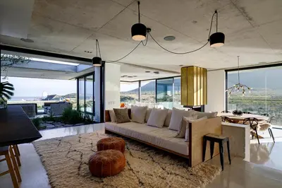 a living room with a couch and a table at Restio River House in Pringle Bay