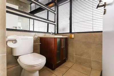 a bathroom with a toilet and a sink at Avemore Eikehoff No 24 full back up power in Stellenbosch