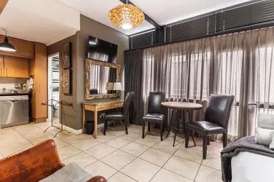 a living room with a table and chairs at Avemore Eikehoff No 24 full back up power in Stellenbosch