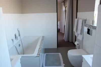 a bathroom with a tub and a toilet and a sink at Seaside Hermanus Guest Room in Hermanus