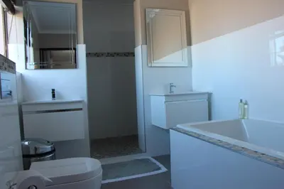 a white bathroom with a sink and a toilet at Seaside Hermanus Guest Room in Hermanus