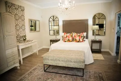 a bedroom with a white bed and a chandelier at Afrika-Pearl in Paarl