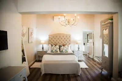 a bedroom with a large bed and a chandelier at Afrika-Pearl in Paarl