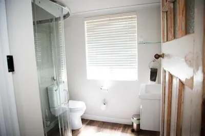 a bathroom with a toilet and a glass shower at Afrika-Pearl in Paarl