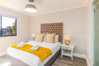 a bedroom with a large bed with a yellow blanket at Quayside 301 by CTHA in Cape Town