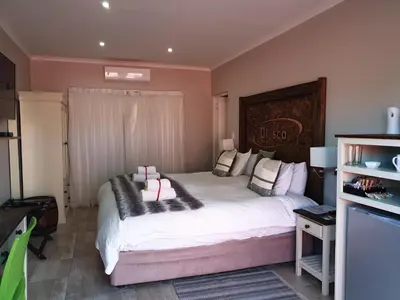 a bedroom with a large white bed with pillows on it at Dilisca Guesthouse in Durbanville