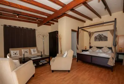 a living room with a couch and chairs and a mirror at Just Unwind in Somerset West
