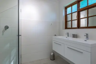 a white bathroom with a sink and a shower at Just Unwind in Somerset West