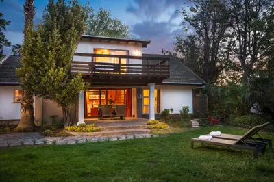 a house with a balcony and a lawn at Just Unwind in Somerset West