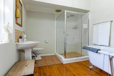 a bathroom with a shower and a sink and a toilet at brookdale house in Cape Town