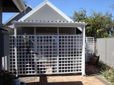 a white fence in front of a house at brookdale house in Cape Town