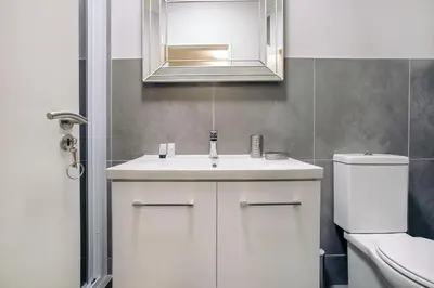 a bathroom with a white sink and a toilet at Superior Apartment Mayfair in Cape Town