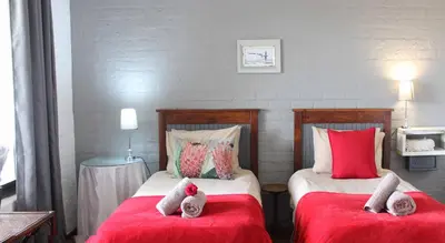 two beds in a room with red and white at Waterside on Le Bonheur in Simondium