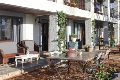 a patio with a table and chairs on a house at Waterside on Le Bonheur in Simondium