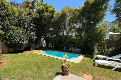 a swimming pool in a yard with a potted plant at Anesta House in Stellenbosch