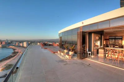 a building with a balcony with a view of the water at Ocean View Penthouse in Strand