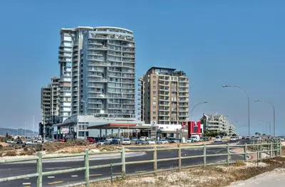two tall buildings in a city with a highway at Portico 802 in Bloubergstrand