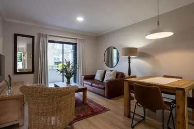 a living room with a table and a couch at Vino Self Catering Apartment in Stellenbosch