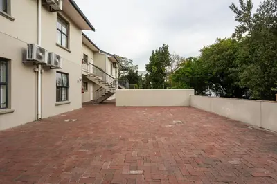 a brick parking lot in front of a building at Vino Self Catering Apartment in Stellenbosch