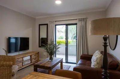 a living room with a couch and a tv at Vino Self Catering Apartment in Stellenbosch