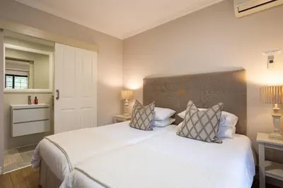 a bedroom with a large white bed with two pillows at Vino Self Catering Apartment in Stellenbosch