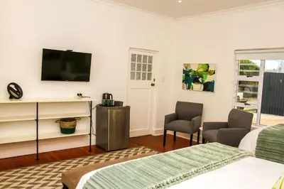 a bedroom with two beds and a flat screen tv at Hermanus Champagne Accommodation in Hermanus