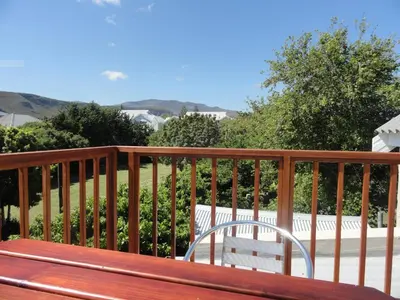 a wooden bench sitting on top of a balcony at The Mayflower in Hermanus