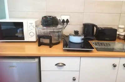 a kitchen counter with a microwave and a laptop at The Mayflower in Hermanus