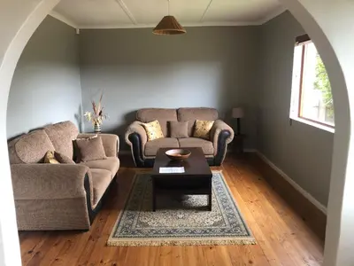 a living room with two couches and a coffee table at Inn On Highlands in Grabouw
