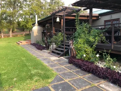 a house with a stairway leading up to a building at Inn On Highlands in Grabouw