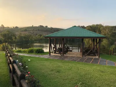 a gazebo in a park next to a lake at Inn On Highlands in Grabouw