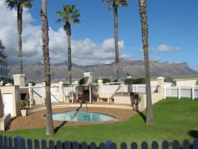 a resort with a swimming pool and palm trees at Emerald Bay in Strand