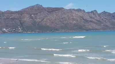 a view of the ocean with mountains in the background at Emerald Bay in Strand