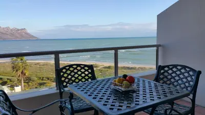 a table with a bowl of fruit on a balcony at Emerald Bay in Strand
